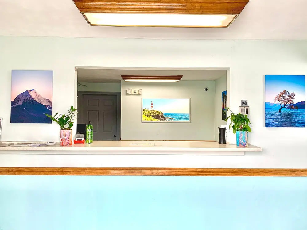 Sandusky Inn front desk with plants and colorful framed art